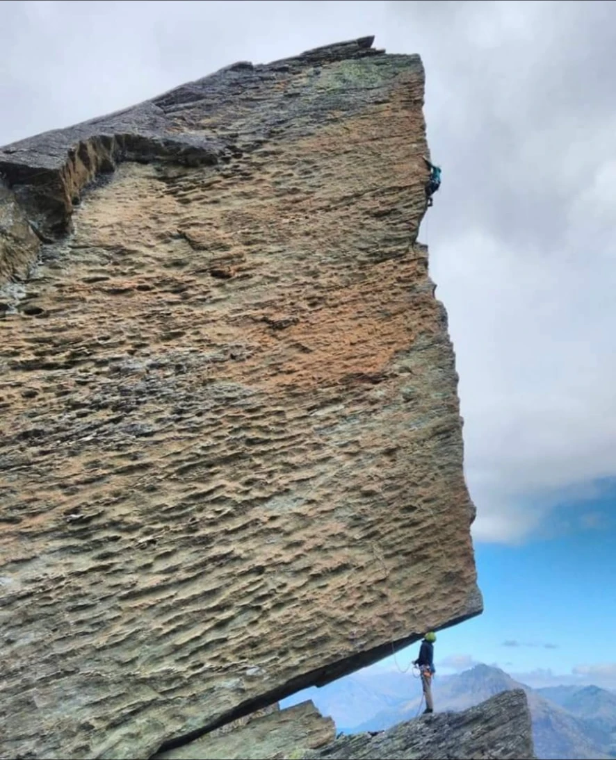 Climbers navigating an overhanging rock formation